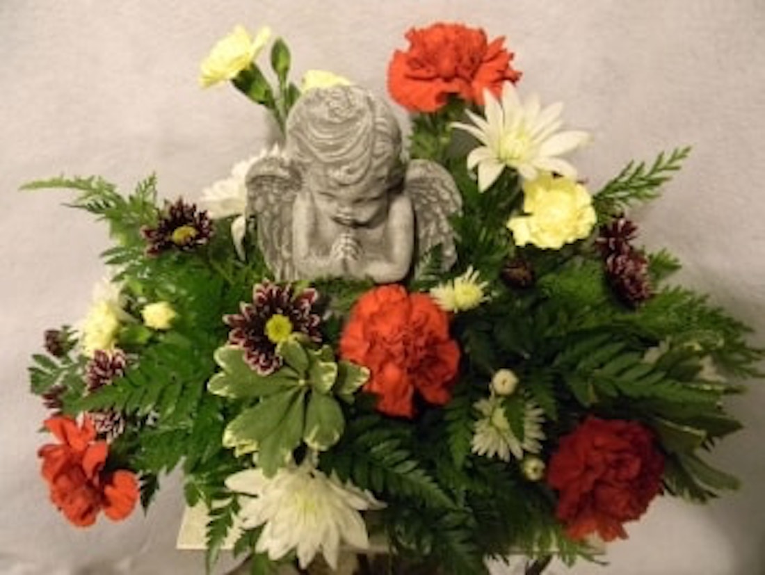 Fresh Arrangement in a Utility Dish With an Angel in the Center